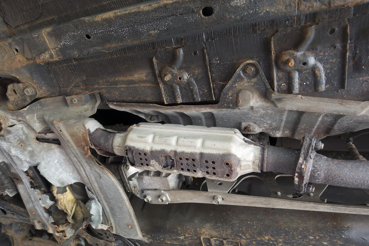 The underside of a car, looking up at the exhaust and mountings